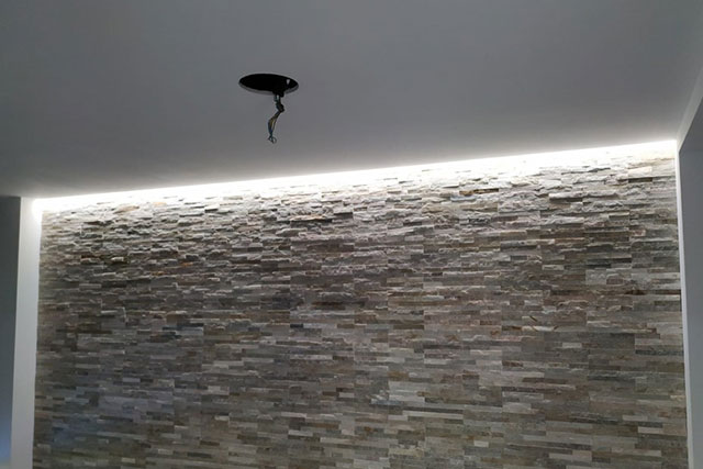 techos con iluminación indirecta y paredes en revestimiento de piedra
